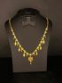 Elegant gold-tone necklace featuring delicate dangling motifs and a vibrant floral pendant for a graceful traditional look