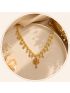 Elegant gold-tone necklace featuring delicate dangling motifs and a vibrant floral pendant for a graceful traditional look