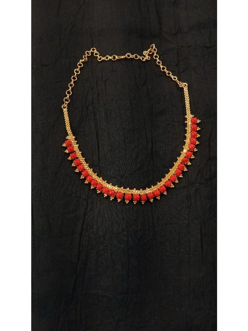 Elegant gold-tone necklace featuring vibrant red bead accents. A timeless statement piece, perfect for weddings, festive occasions, and party wear