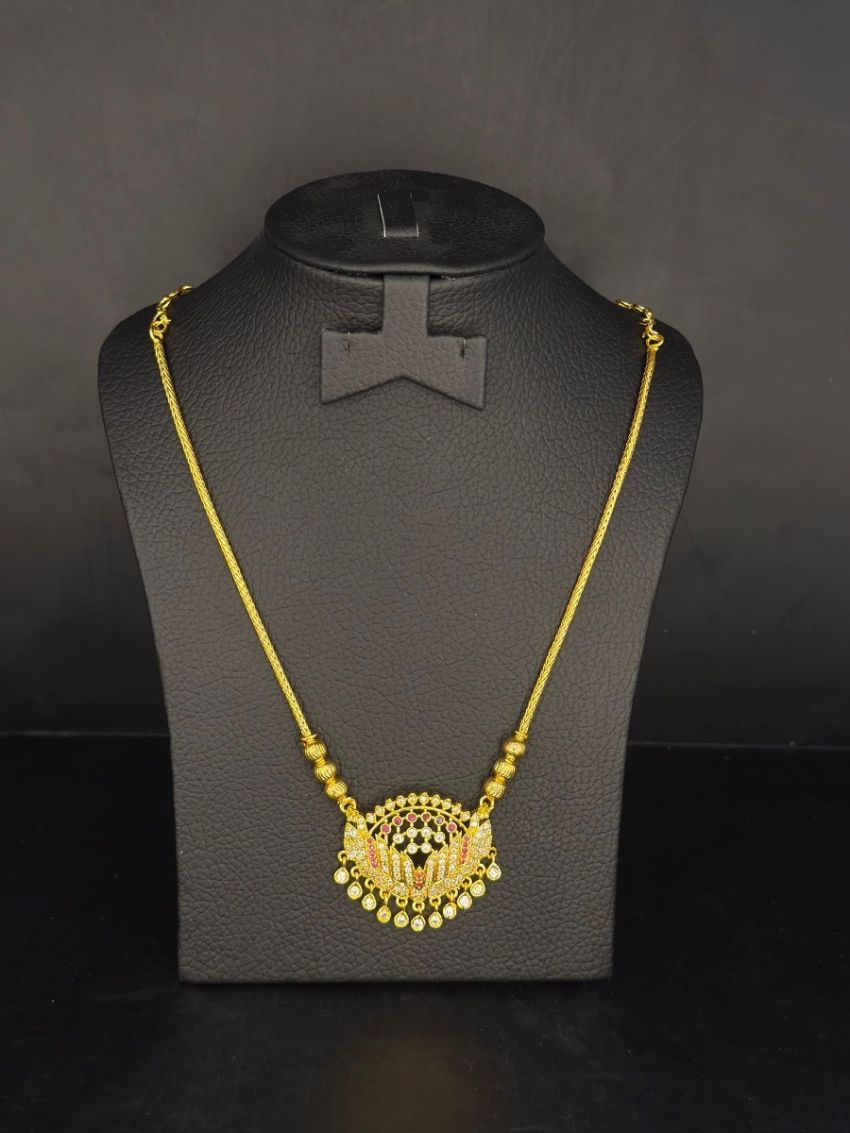 Elegant gold-tone necklace featuring a dazzling stone-studded floral pendant with delicate dangling accents for a graceful finish