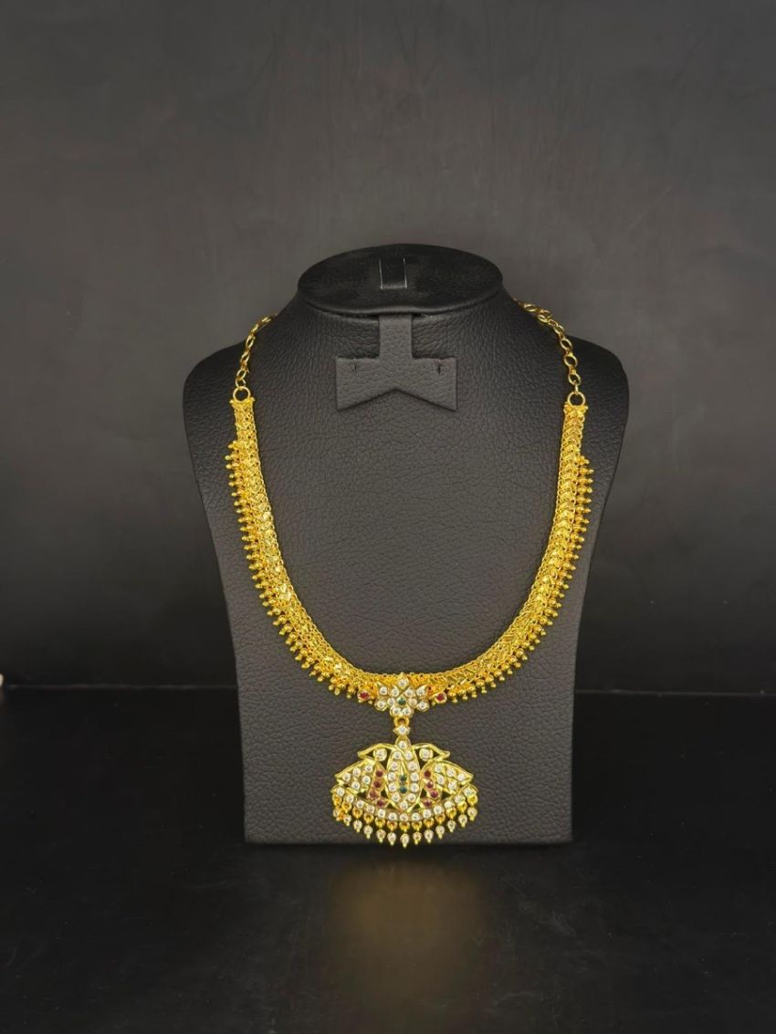 Elegant gold-tone necklace featuring a sparkling stone-studded pendant with intricate traditional detailing.