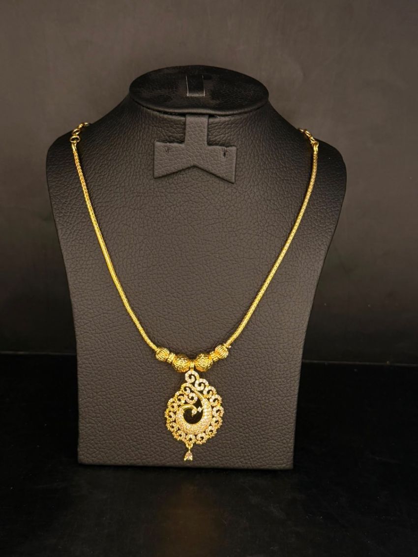 Elegant gold-tone necklace featuring an intricately crafted peacock-inspired pendant with sparkling stone detaili