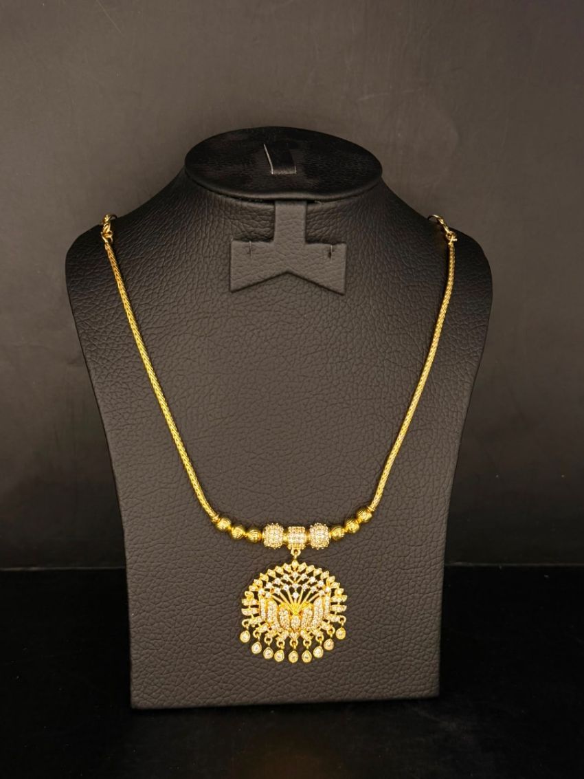 Elegant gold-tone necklace featuring a dazzling butterfly-inspired pendant adorned with sparkling stones and delicate hanging accents.